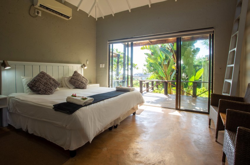 Bedroom 1 with view of the garden at Baleia Azul 15 in Ponta Mamoli