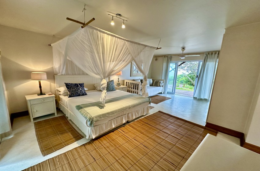 bedroom 1 with open patio door at kangela 11 in Ponta Malongane